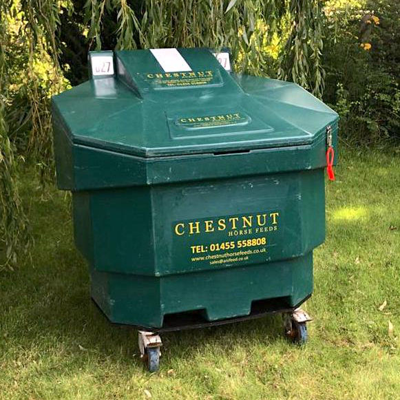 a photo of a woman opening a Bulk Bin for her horse