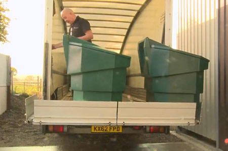 a photo of a man carefully loading a Bulk Bin into a van